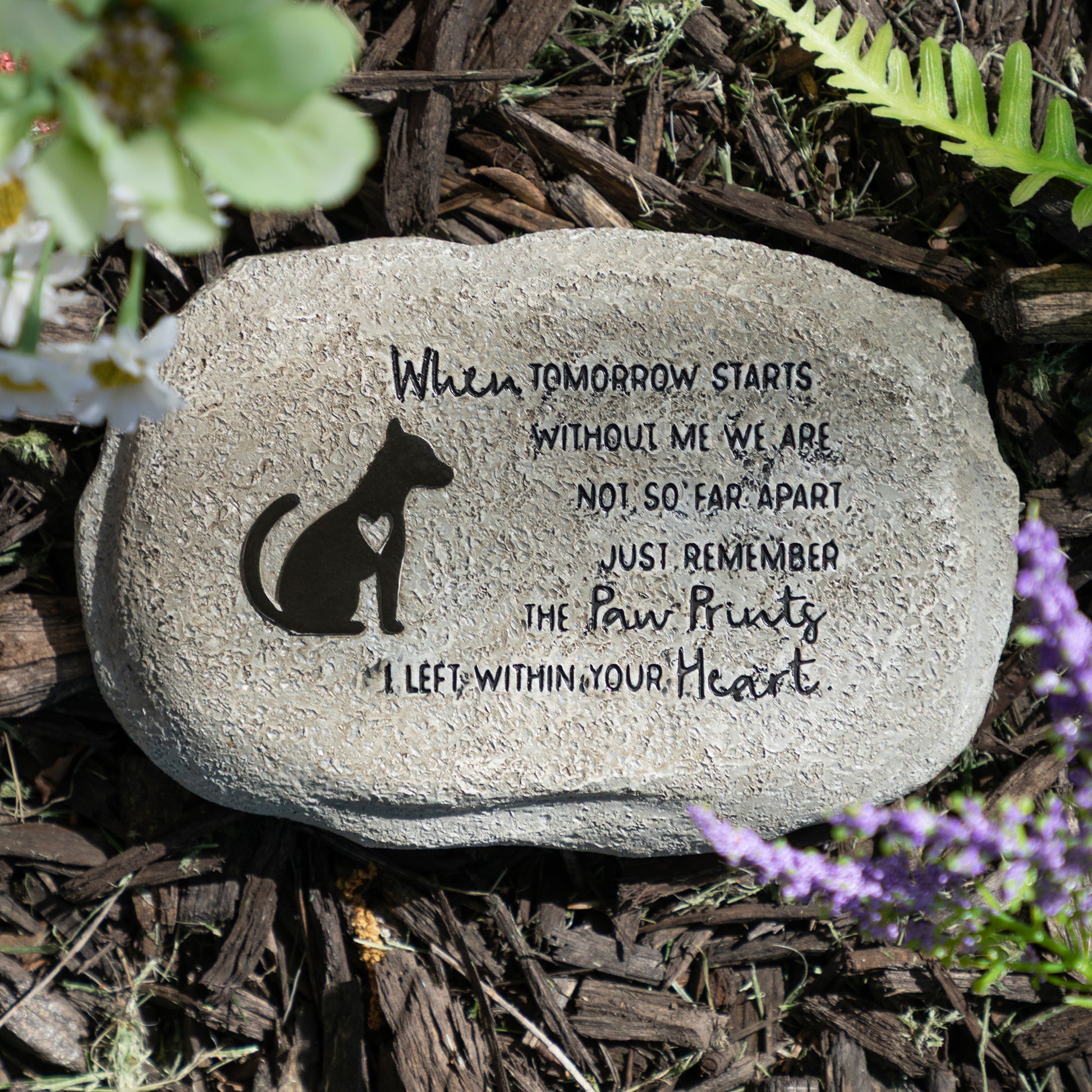 Decorative stone with a dog silhouette and engraved text on a natural background
