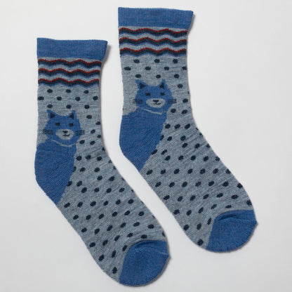 A pair of blue and gray patterned crew socks featuring a blue cat design on the side and a striped cuff, displayed on a light gray background.